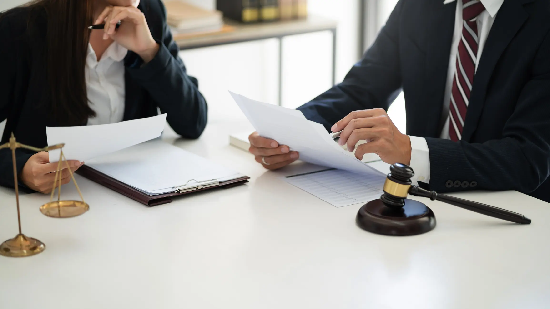 Lawyer with lawsuit meeting with client discussing with contract agreement at courtroom.
